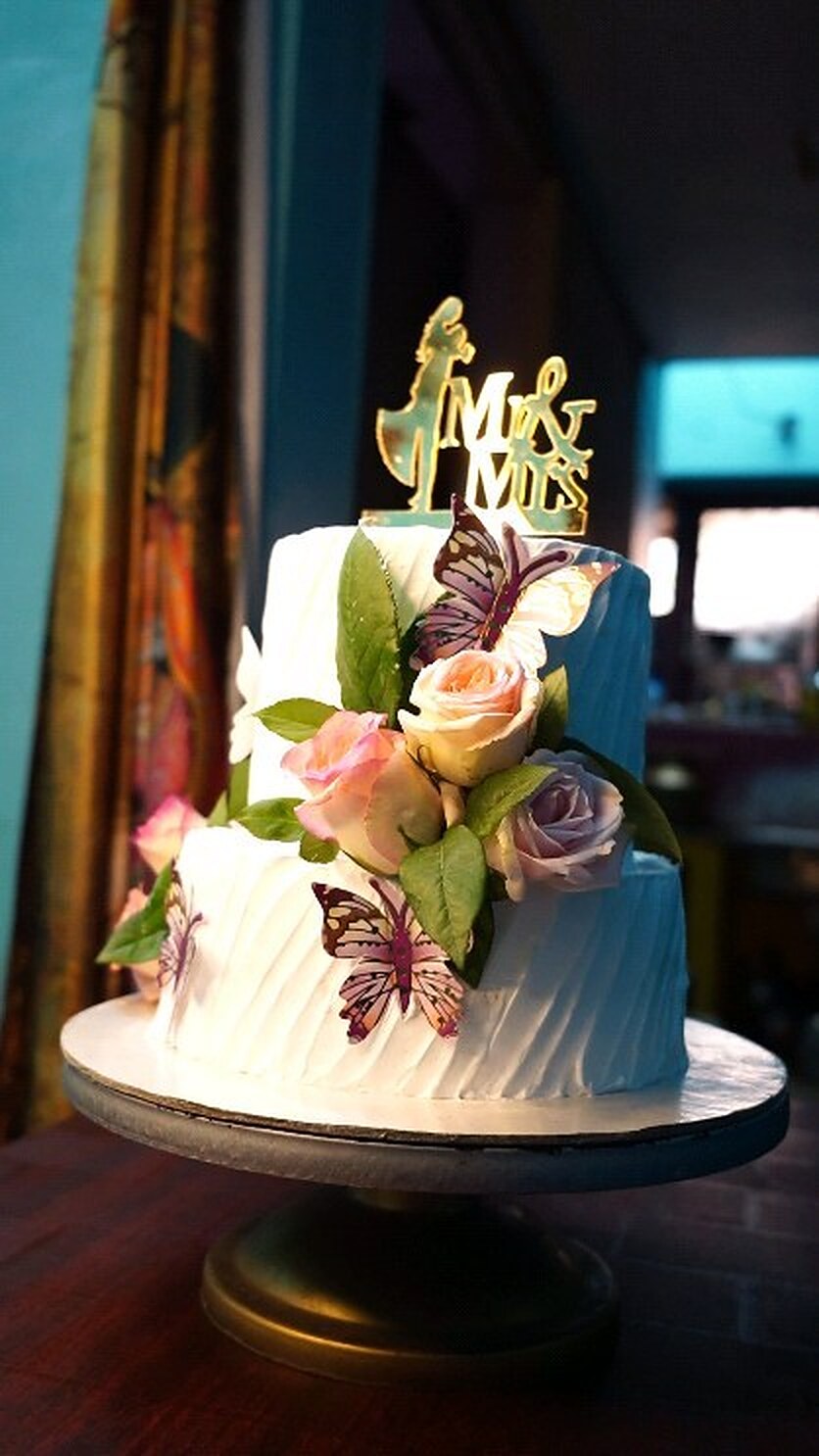 White wedding cake with fresh roses and a Mr and Mrs topper